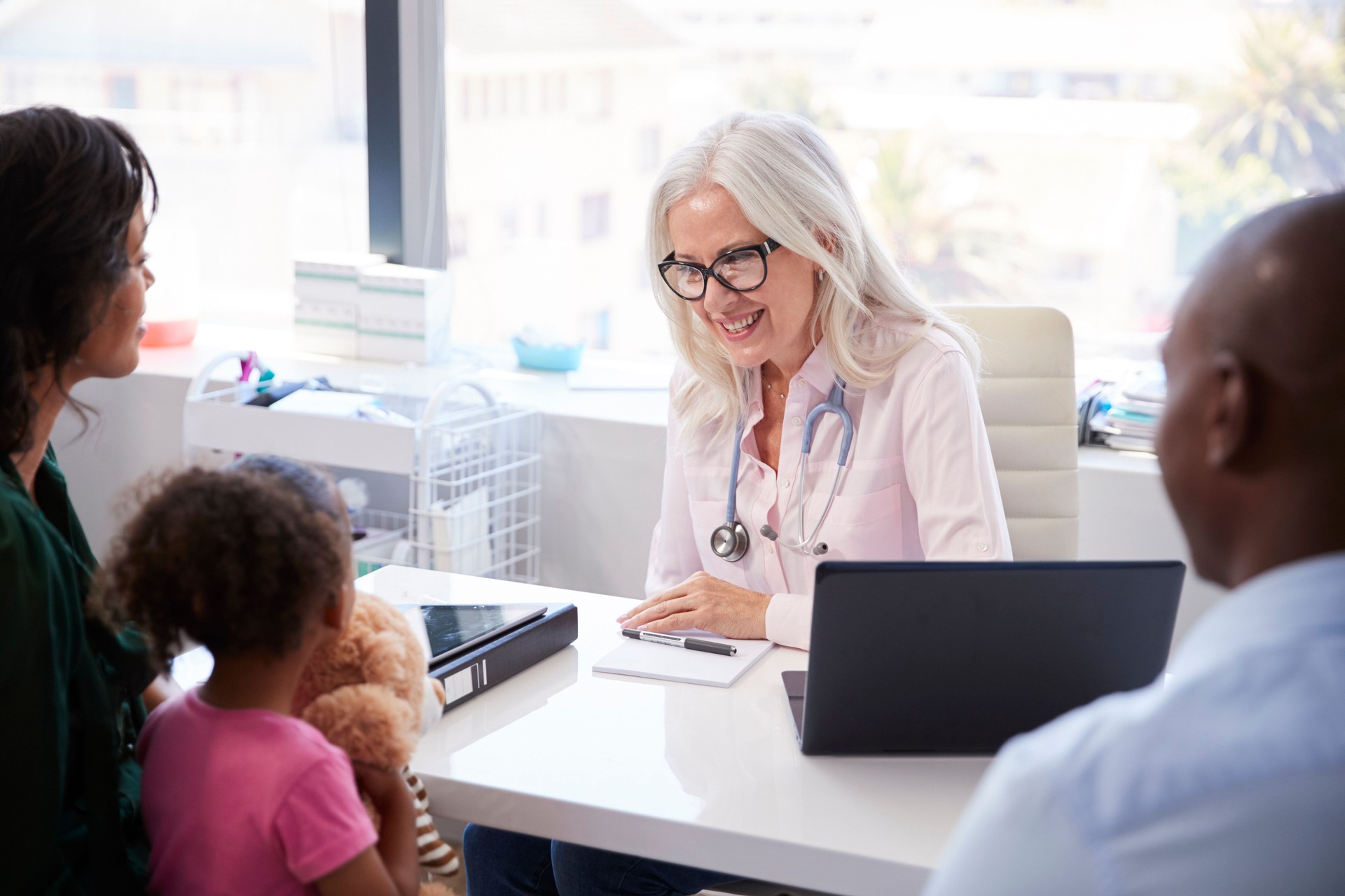 Família com a filha na consulta com o doutor no escritório