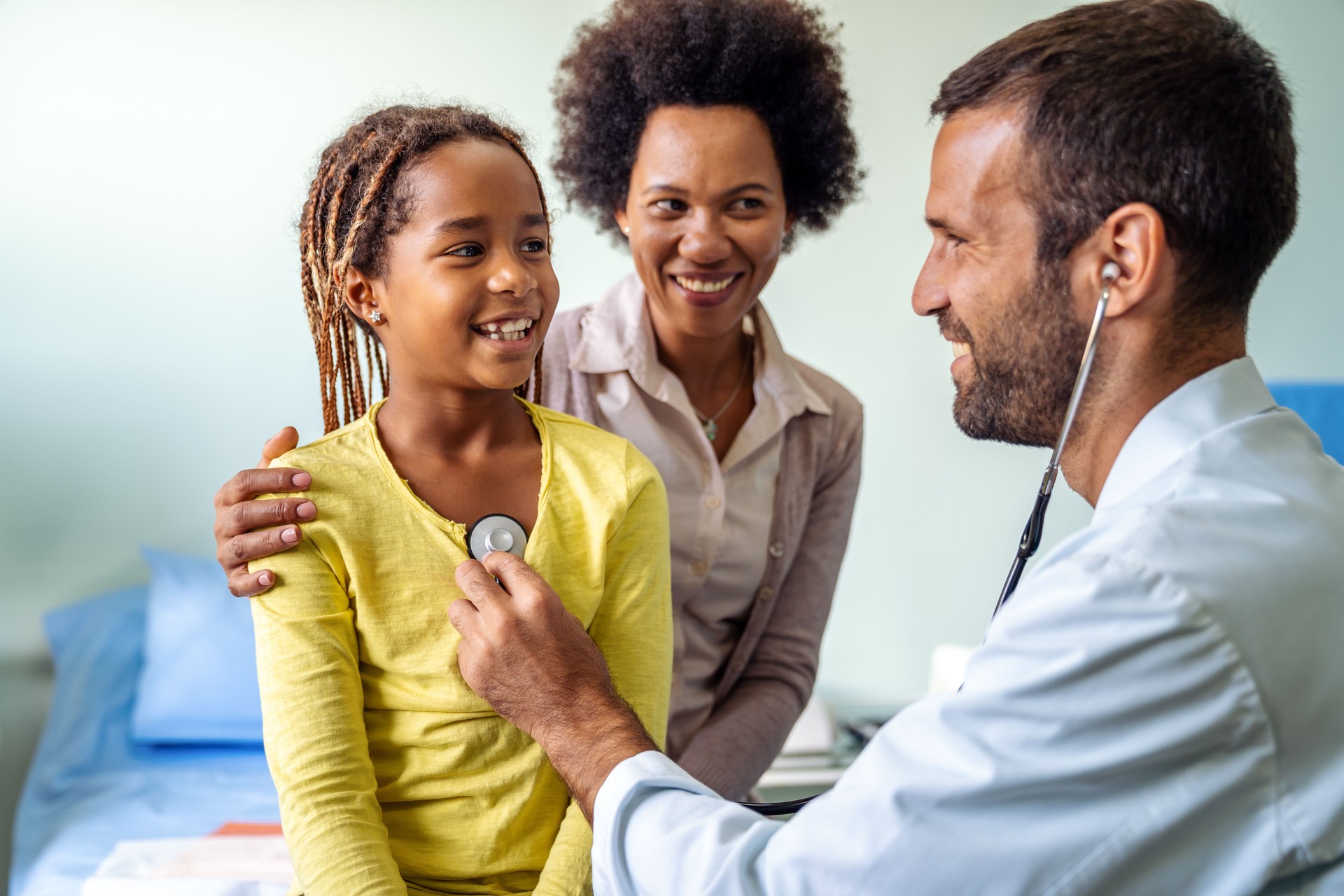 Male doctor examining a child patient in a hospital